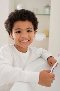 happy kid brushing his teeth image
