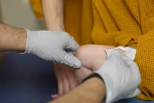a baby is given a shot in the thigh